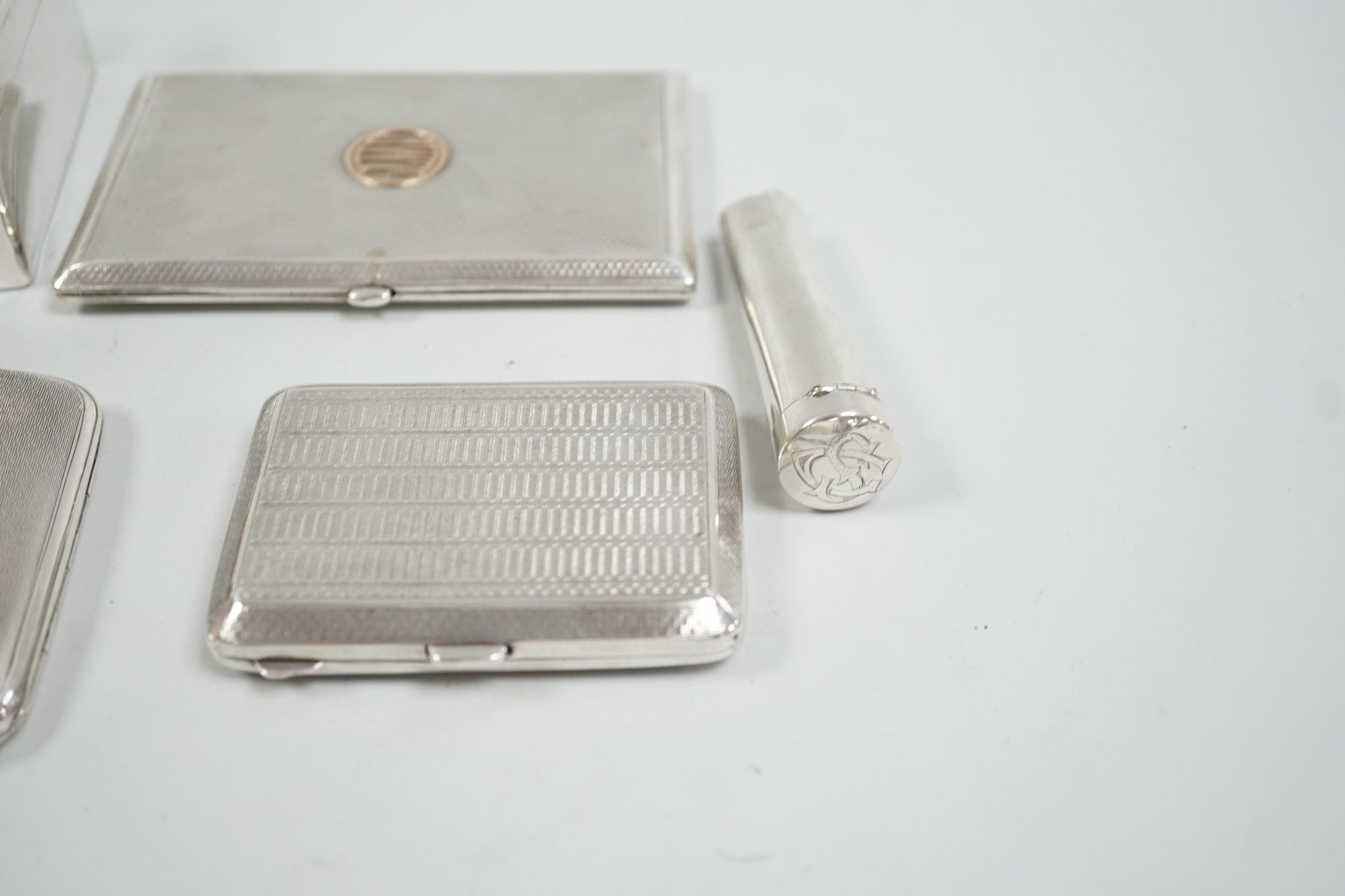 A George V silver mounted cigarette box, 10.5cm, three assorted engine turned silver cigarette cases and a silver cheroot case.